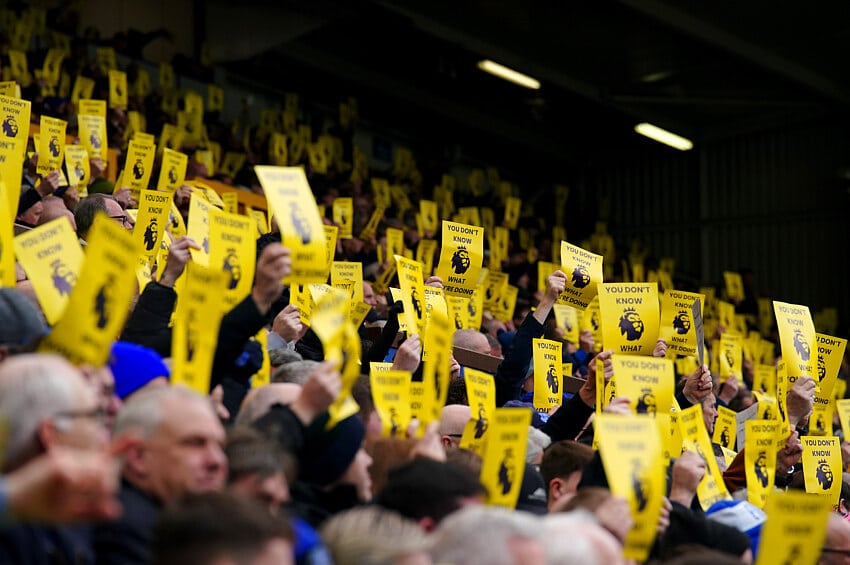 Everton fans hold up banners aimed towards the Premier League