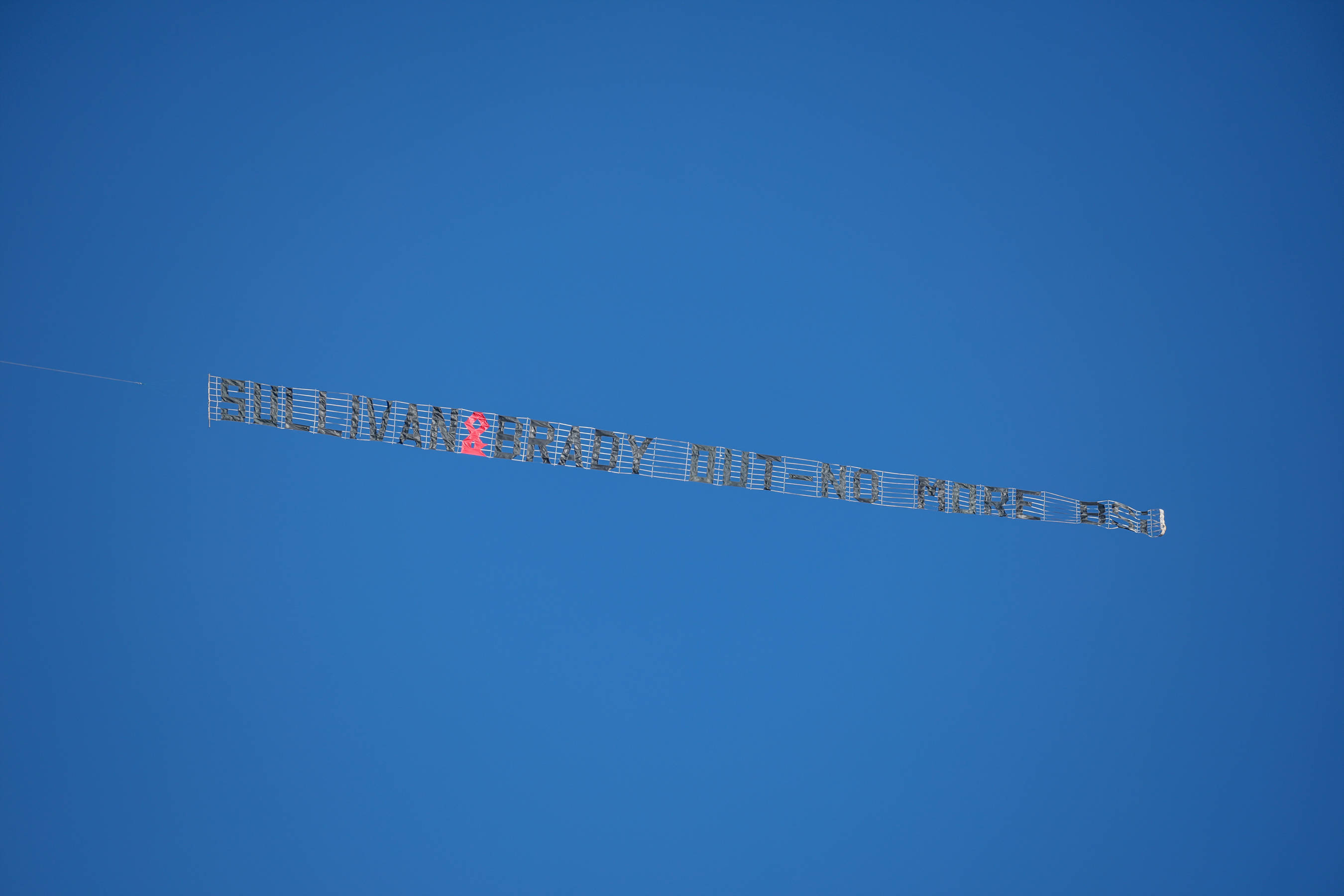 A light aircraft tows a banner calling for West Ham United owners to quit